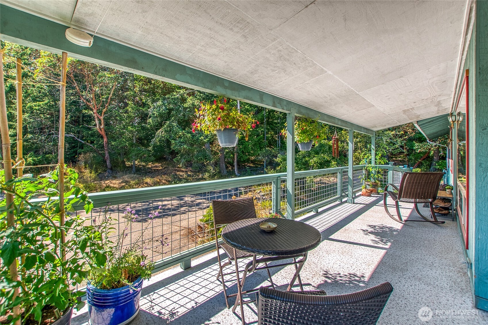 239 Killebrew Lake Road Orcas Island, WA 98280 - Photo 3 of 31 a roof deck with table and chairs potted plants and a palm tree