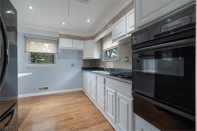 a kitchen with stainless steel appliances kitchen island wooden cabinets and stove