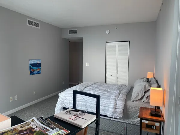 a bedroom with a bed and large window