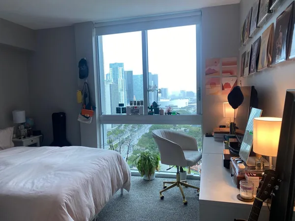 a bed room with a bed television and a large window