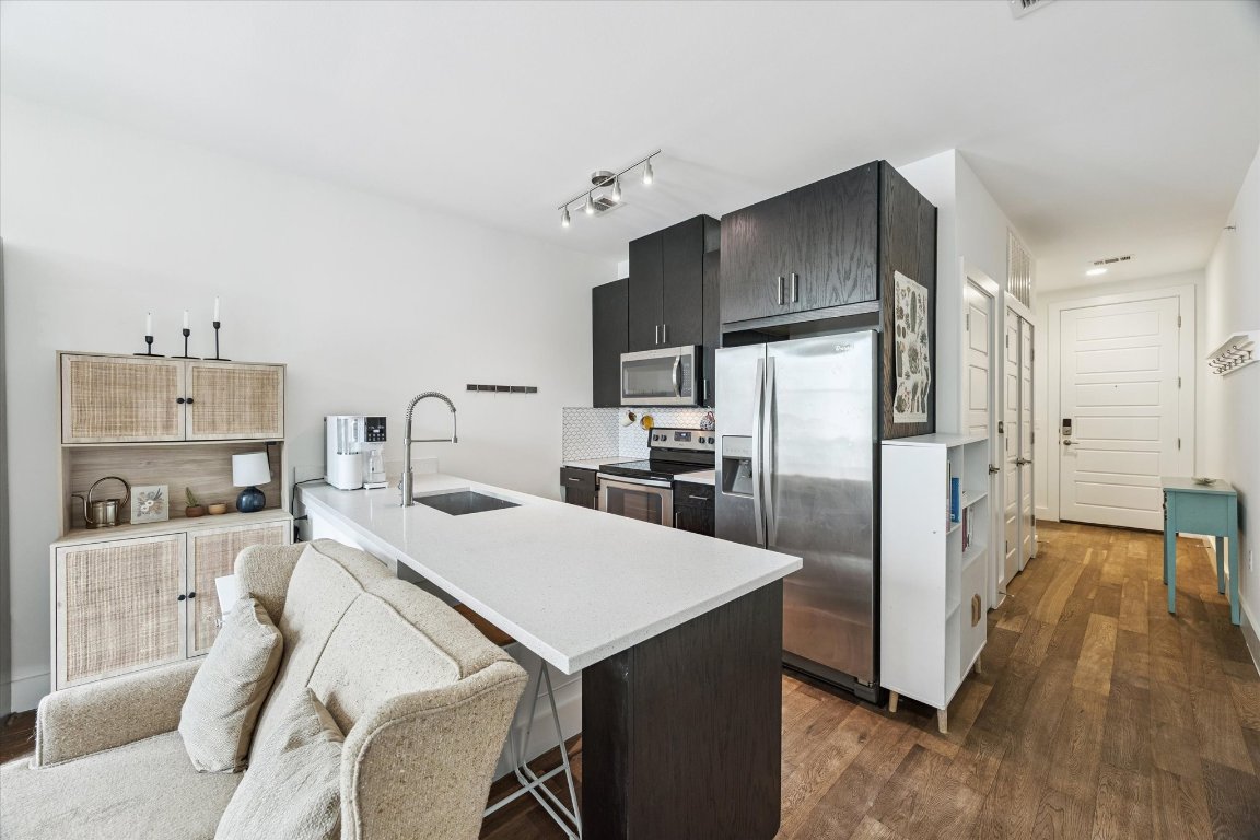 a kitchen with a refrigerator a sink and cabinets