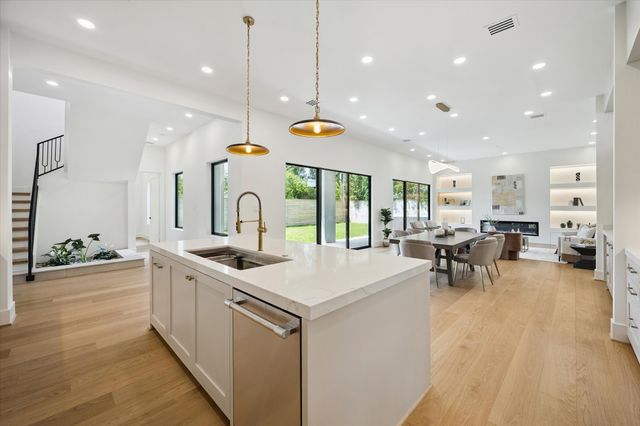 a kitchen with stainless steel appliances granite countertop sink stove and wooden floor