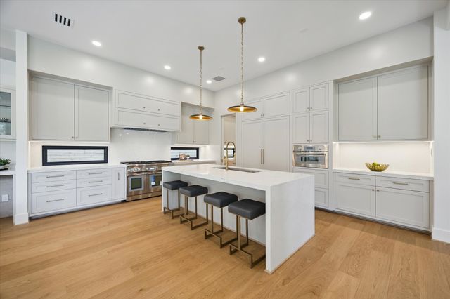 a kitchen with white cabinets and stainless steel appliances