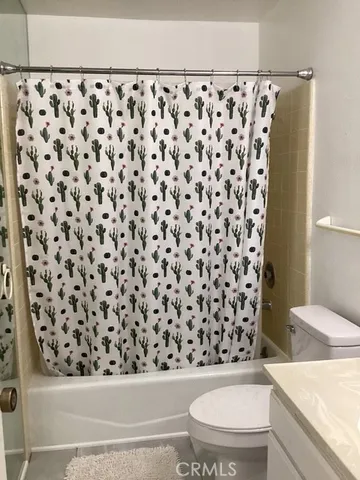 a bathroom with a toilet and a shower curtain