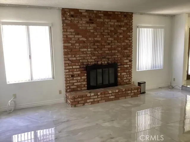 a view of an empty room with a fireplace and a window