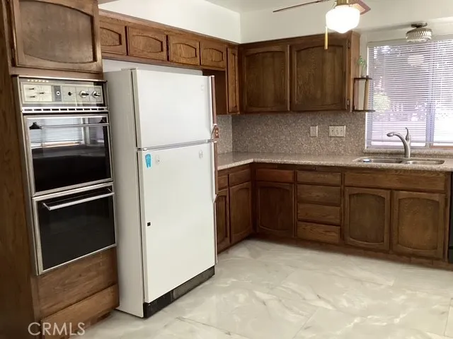 a kitchen with stainless steel appliances granite countertop a refrigerator and a sink