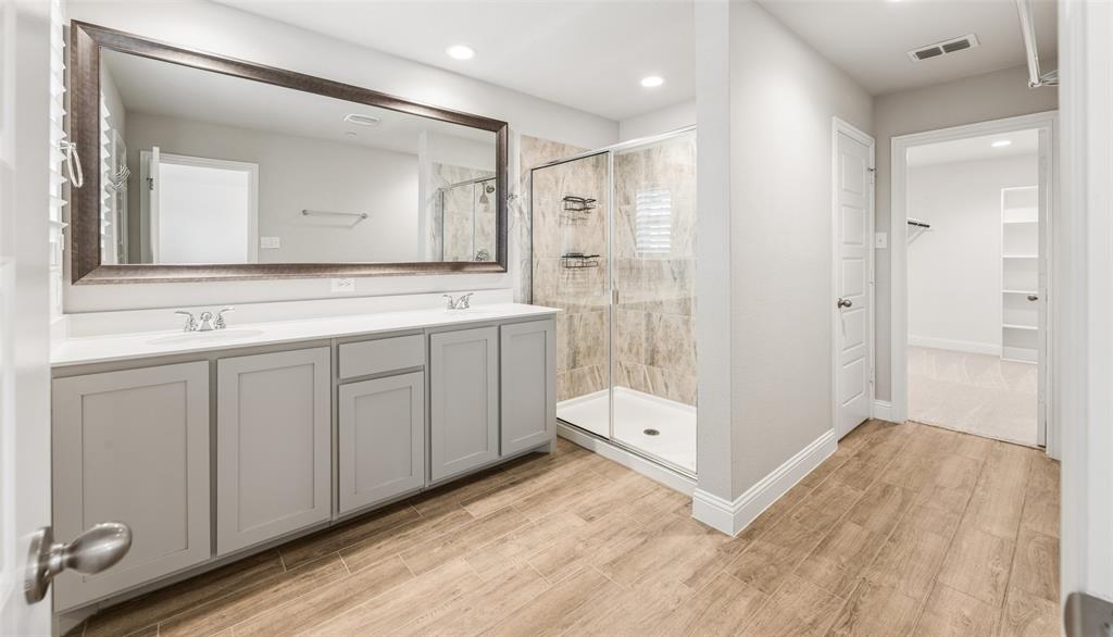6020 Bursey Road Watauga, TX 76148 - Photo 22 of 33 a bathroom with a sink a mirror and a shower
