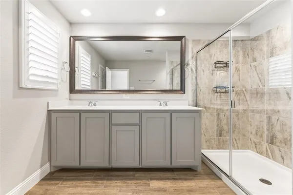 a bathroom with a tub a sink and a large mirror