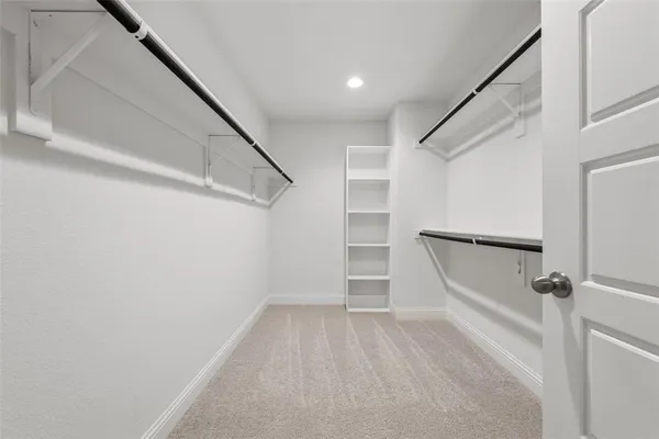 a view of walk in closet with empty racks