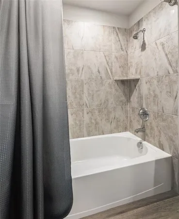 a bathroom with bathtub and shower