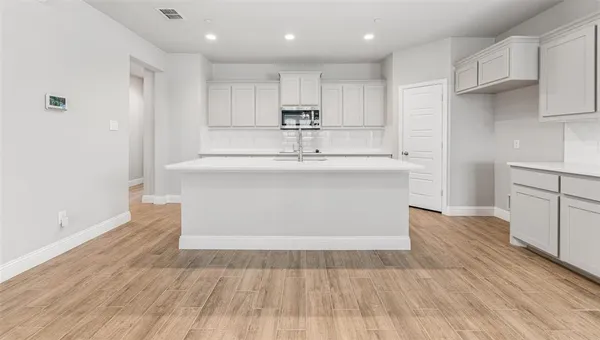 a view of kitchen with wooden floor and electronic appliances