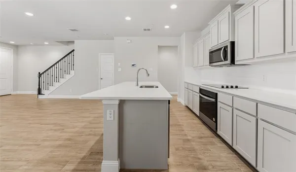 a kitchen with stainless steel appliances a sink dishwasher stove top oven and refrigerator