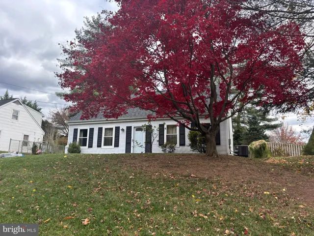 a front view of house with yard and trees around