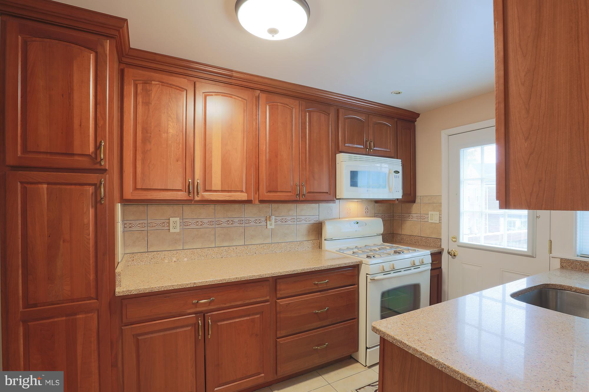 1727 Edgewood Road Towson, MD 21286 - Photo 18 of 29 a kitchen with stainless steel appliances granite countertop a sink stove and refrigerator with wooden floor