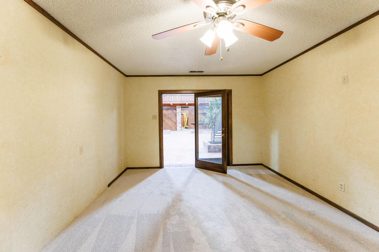 409 Mill Road Lubbock, TX 79403 - Photo 61 of 86 an empty room with a chandelier fan and windows