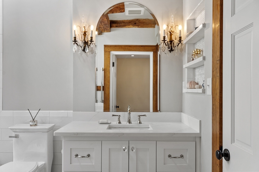 394 Plainfield Road, Unit 394 Concord, MA 01742 - Photo 30 of 40 a bathroom with a granite countertop sink a toilet and a mirror