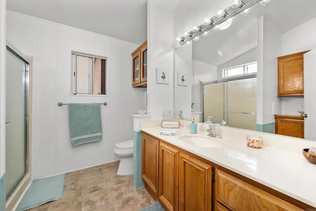 a bathroom with a double vanity sink toilet and mirror