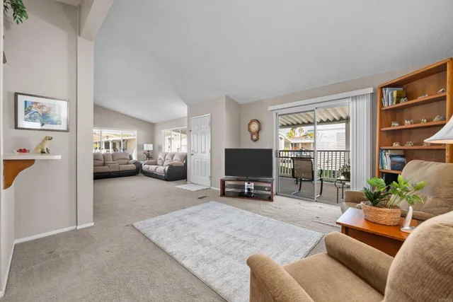 a living room with furniture a window and a flat screen tv