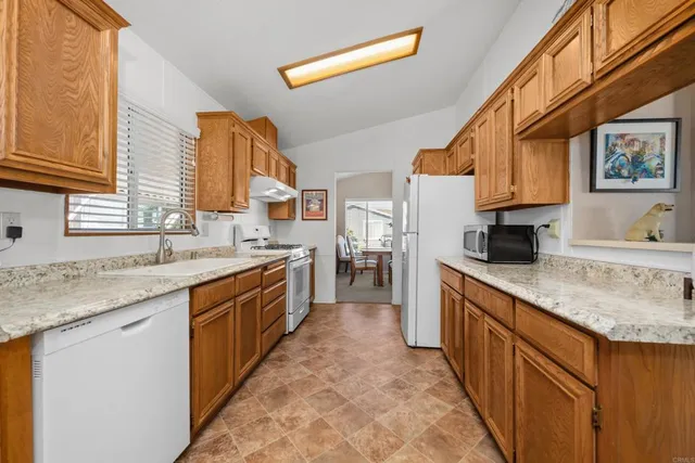 a large kitchen with stainless steel appliances granite countertop a sink and a stove