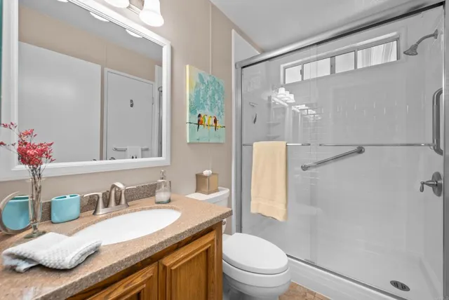 a bathroom with a granite countertop sink toilet and shower