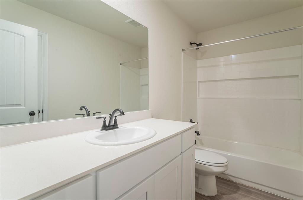 404 Rose Avenue Cleburne, TX 76033 - Photo 11 of 14 a bathroom with a sink toilet and shower
