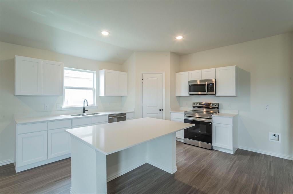 404 Rose Avenue Cleburne, TX 76033 - Photo 5 of 14 a kitchen with stainless steel appliances granite countertop a stove top oven a sink dishwasher and a refrigerator with wooden floor
