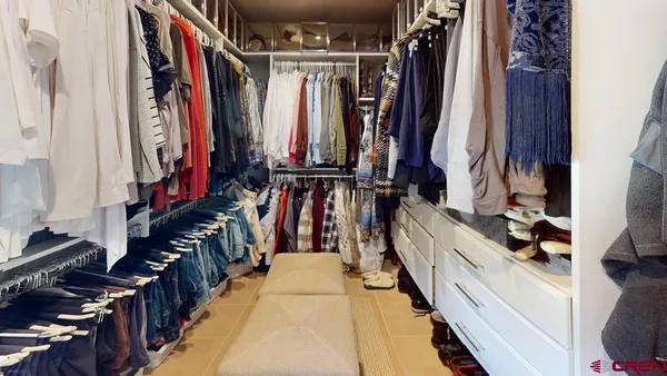 a view of walk in closet with clothes