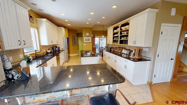 a large kitchen with stainless steel appliances granite countertop a large counter top and a stove