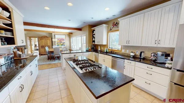 a kitchen with stainless steel appliances granite countertop a stove a sink dishwasher and cabinets with wooden floor