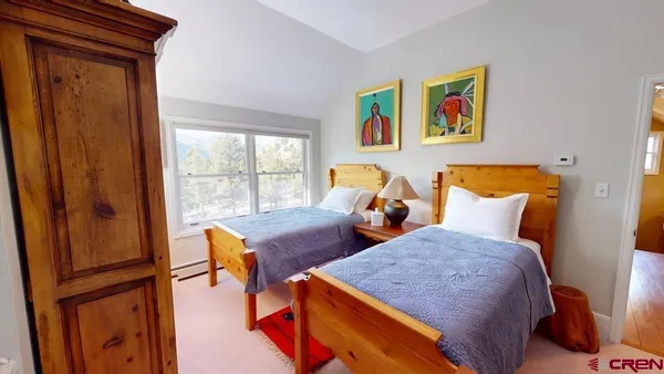 a bedroom with two beds and painting on the wall