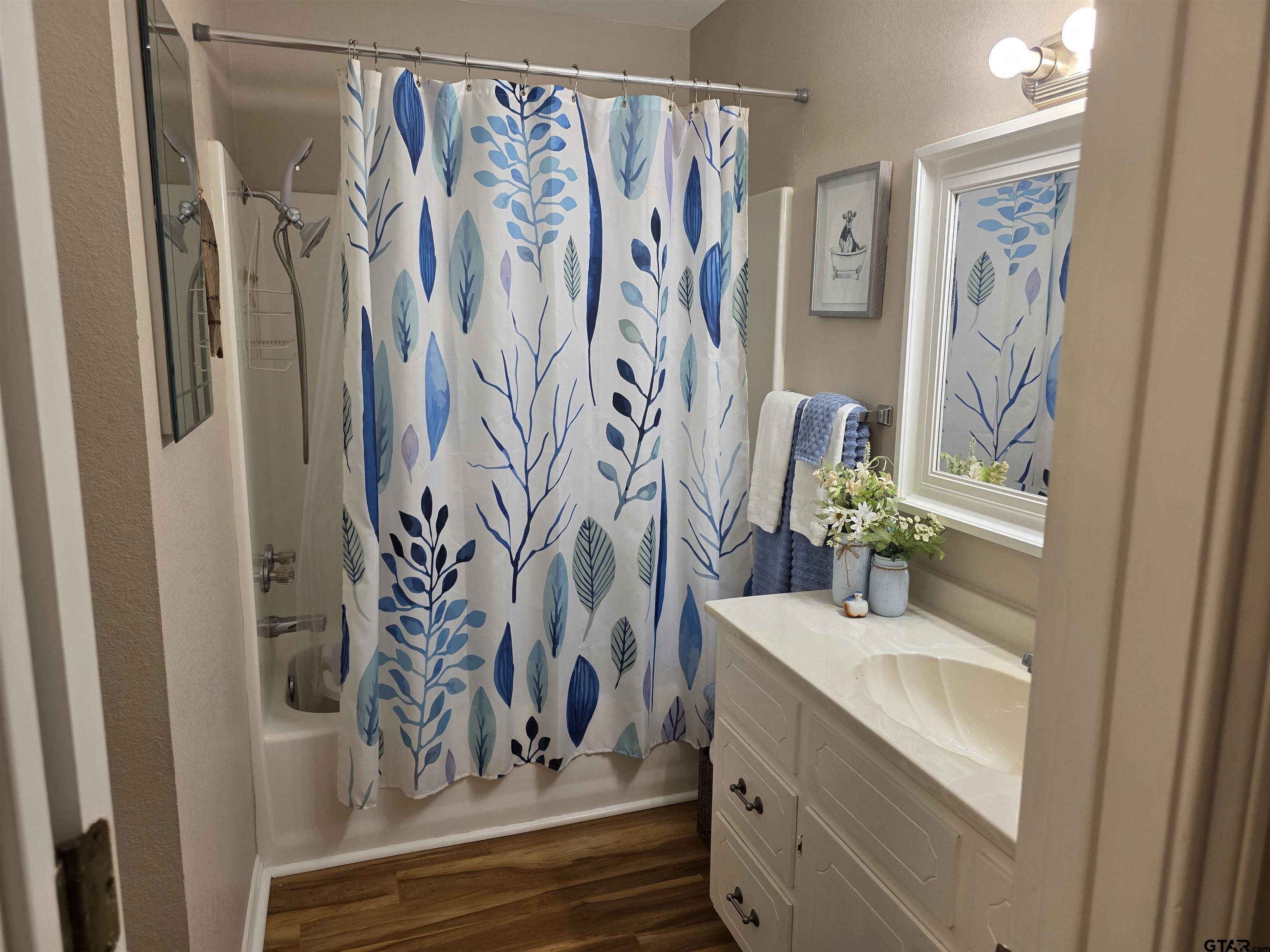 6170 Highway 271 Mount Pleasant, TX 75455 - Photo 25 of 43 a bathroom with a granite countertop sink a mirror and a shower curtain