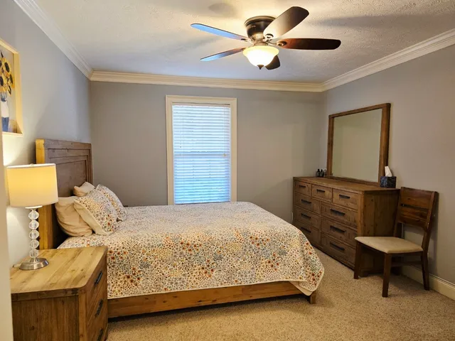 a bedroom with a bed a couch and a chandelier