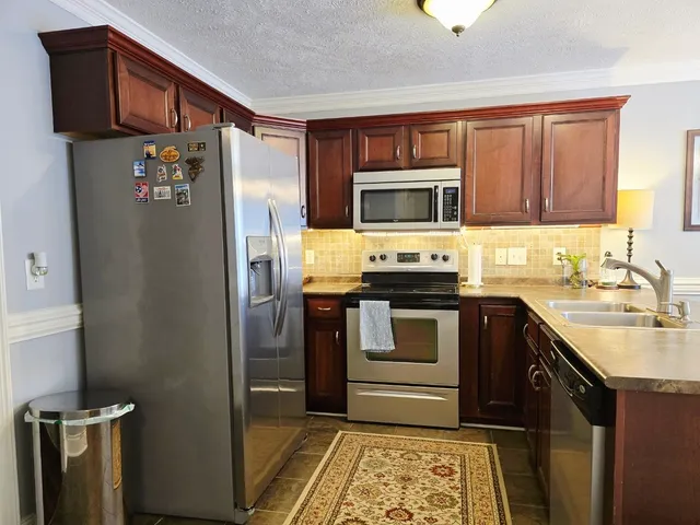 a kitchen with stainless steel appliances granite countertop a refrigerator stove and sink