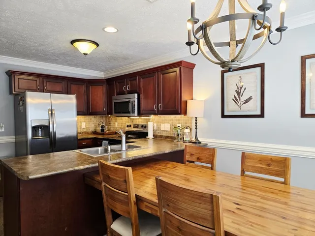 a kitchen with stainless steel appliances granite countertop a sink dishwasher stove and refrigerator with wooden floor