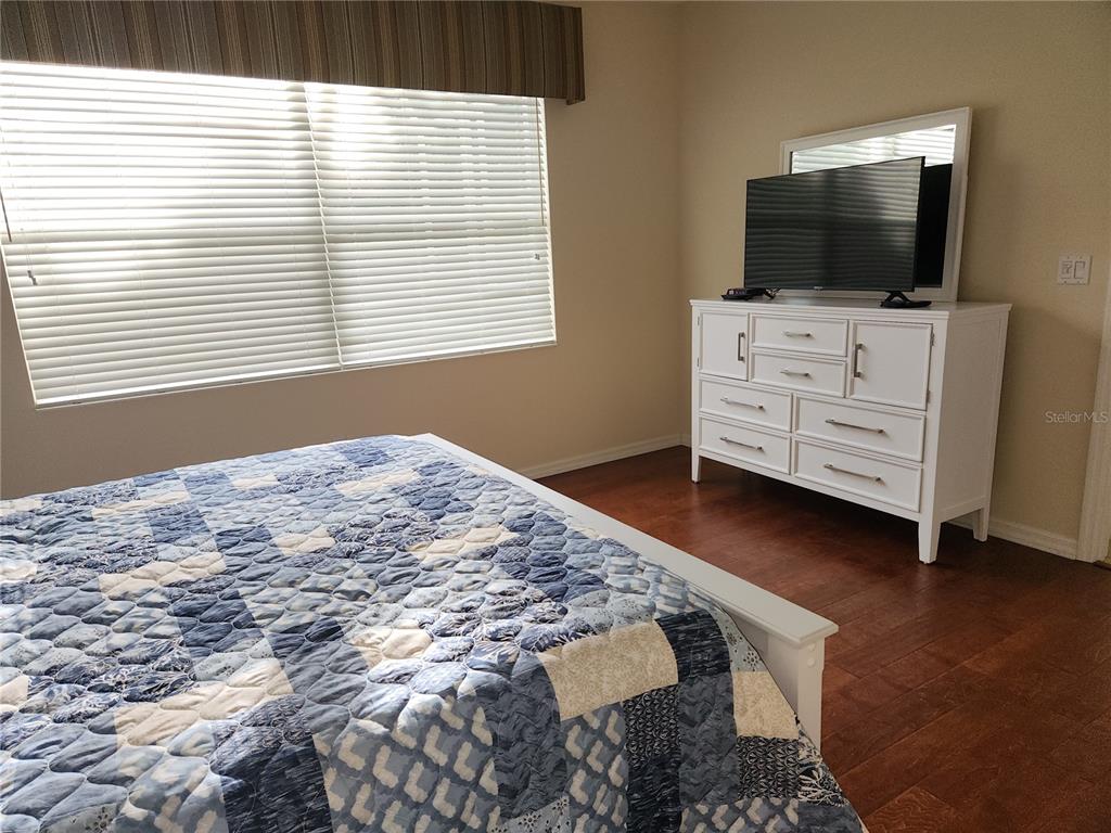 6642 Tailfeather Way Bradenton, FL 34203 - Photo 15 of 28 a bedroom with a bed and flat screen tv