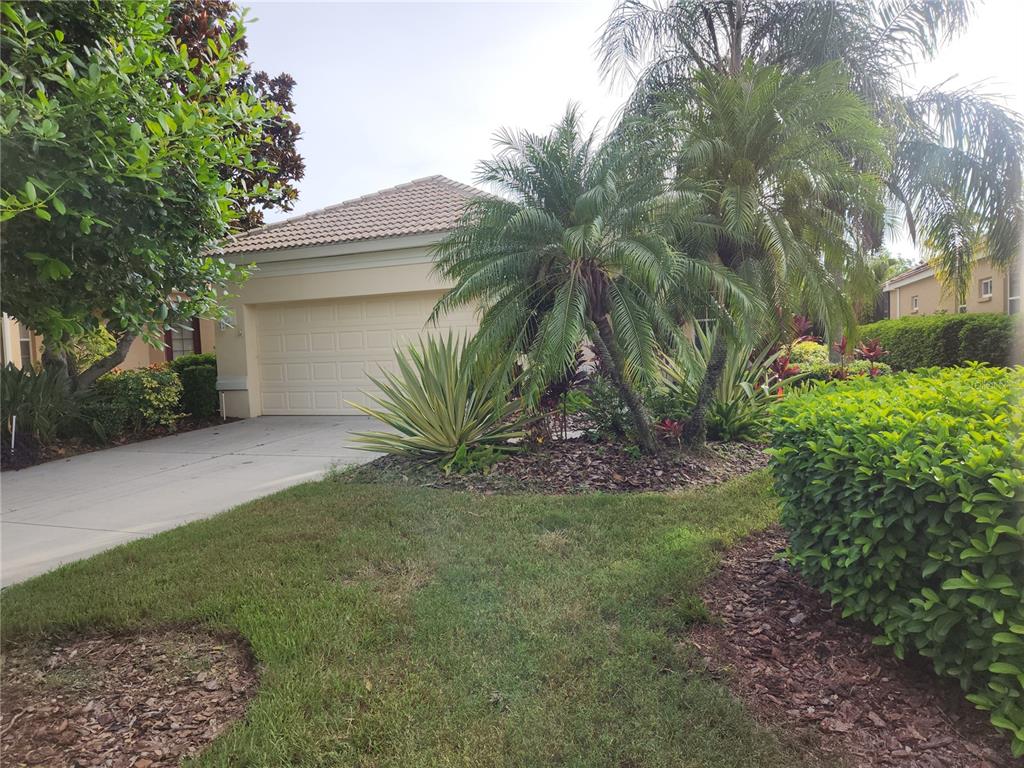 6642 Tailfeather Way Bradenton, FL 34203 - Photo 2 of 28 a view of a house with a yard and palm trees