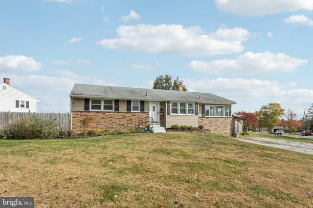 a big white house with a big yard plants and big trees