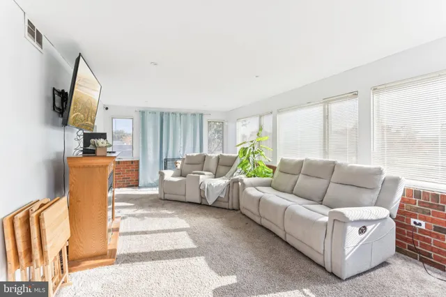 a living room with furniture a flat screen tv and a large window