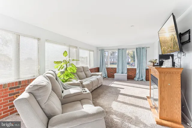 a living room with furniture a large window and a rug