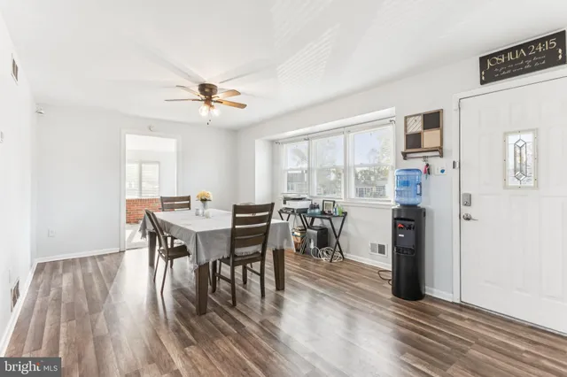 a view of a a dining room with furniture window and wooden floor