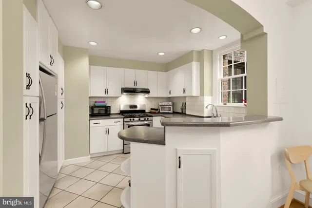 a kitchen with stainless steel appliances granite countertop a refrigerator and a sink