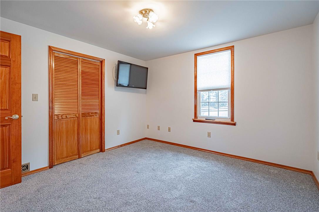 4165 East Texas Road Allentown, PA 18103 - Photo 44 of 56 A quiet bedroom showcases a louvered closet, warm wood trim, and a bright window.
