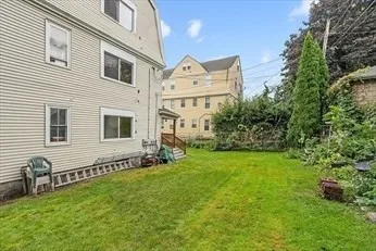 a view of a house with backyard and a tree