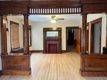 a view of an empty room with wooden floor and a window