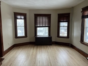 3 View Street, Unit 1 Worcester, MA 01610 - Photo 3 of 12 a view of an empty room with wooden floor and a window