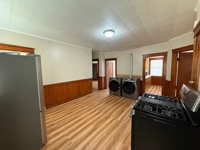 a view of a kitchen with wooden floor and cabinets