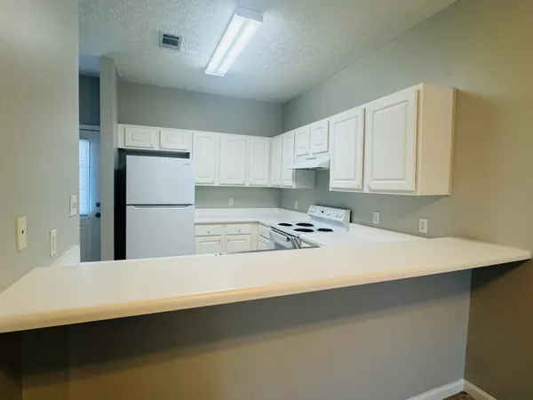 a kitchen with white cabinets appliances and a sink