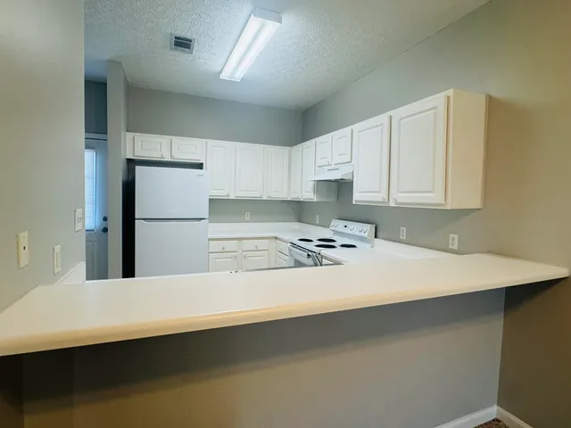 a kitchen with white cabinets appliances and a sink