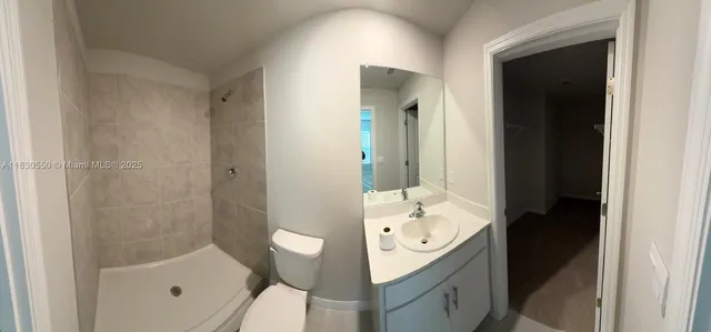 an empty room with windows and ceiling fan