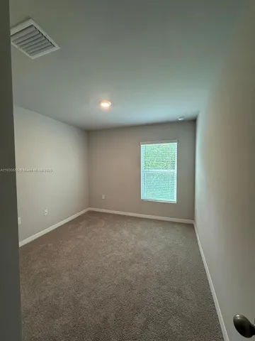 an empty room with mirror and door